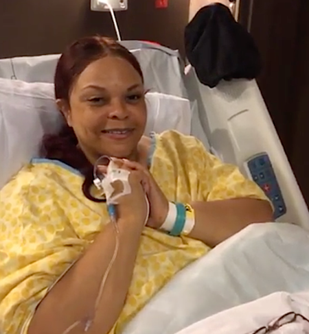 tamela in the hospital bed wearing a yellow hospital gown 
